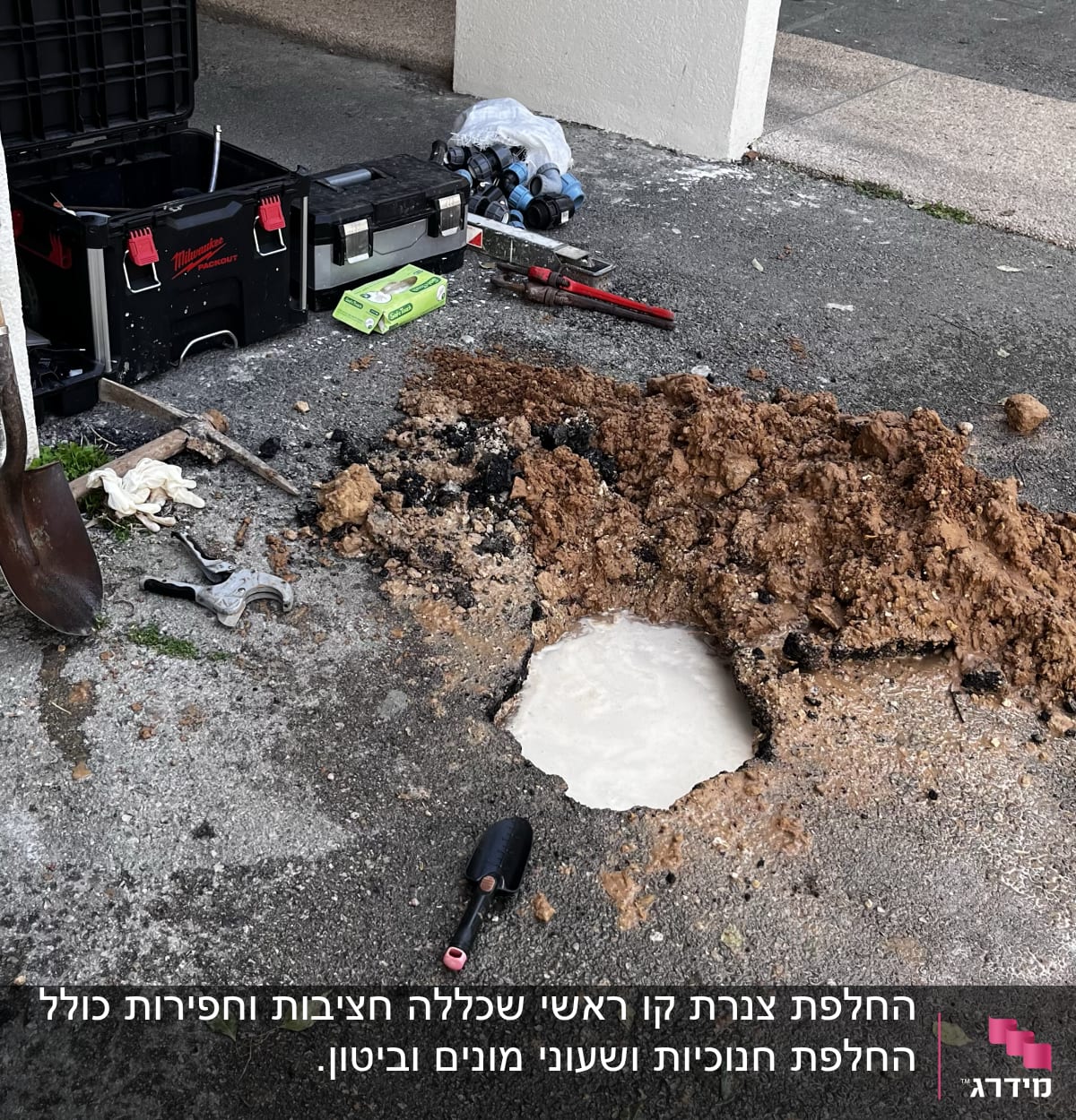 כלי עבודה של אינסטלטור ליד בור פתוח באדמה